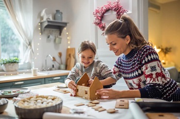 mother and daughter making a gingerbread house